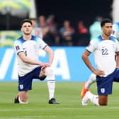 Declan Rice, Jude Bellingham and Harry Maguire of England take a knee prior to the FIFA World Cup Qatar 2022 Group B match between England and IR Iran at Khalifa International Stadium.