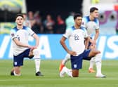 Declan Rice, Jude Bellingham and Harry Maguire of England take a knee prior to the FIFA World Cup Qatar 2022 Group B match between England and IR Iran at Khalifa International Stadium.