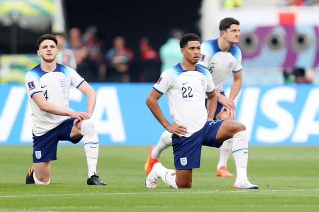 Declan Rice, Jude Bellingham and Harry Maguire of England take a knee prior to the FIFA World Cup Qatar 2022 Group B match between England and IR Iran at Khalifa International Stadium.