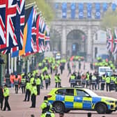 Police officers and security employees gather on The Mall ahead of the Coronation of King Charles III and Queen Camilla