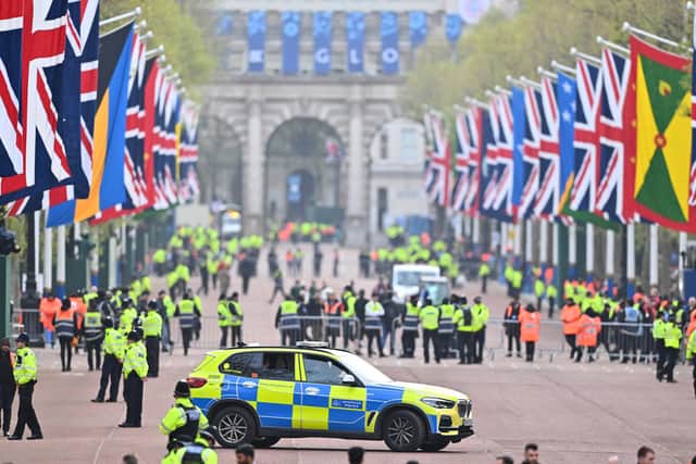 Police officers and security employees gather on The Mall ahead of the Coronation of King Charles III and Queen Camilla