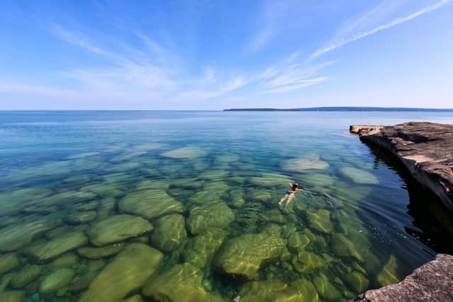 A girl swims in Lake Superior in the glass-like, pristine waters of Lake Michigan (Picture: C Sterken/Getty)