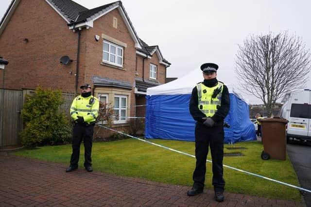 Officers from Police Scotland stand beside by police tape and a police tent outside the home of former chief executive of the Scottish National Party (SNP) Peter Murrell