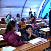 Syrian children take lessons in a makeshift school tent in a refugee camp in Turkey in 2015.