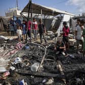 Palestinians inspect the damage at a tent area in the courtyard of Al Aqsa Martyrs hospital, hit by an Israeli bombardment on Deir al-Balah. Picture: AP Photo/Abdel Kareem Hana