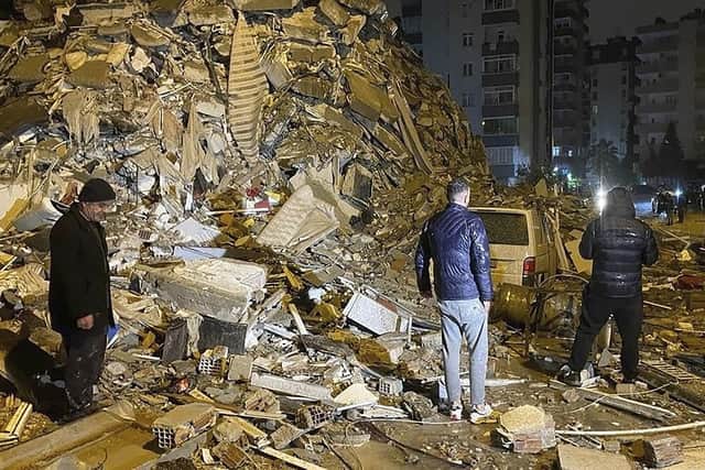 People try to reach trapped residents inside collapsed buildings in Diyarbakir, southern Turkey, early Monday, Feb. 6, 2023. A powerful earthquake has caused significant damage in southeast Turkey and Syria and many casualties are feared. Damage was reported across several Turkish provinces, and rescue teams were being sent from around the country.(Depo Photos via AP)
