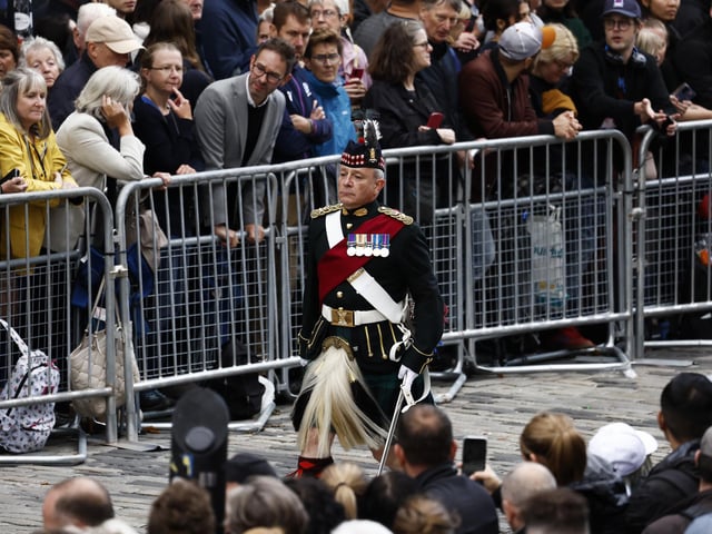 A soldier walks near Mercat Cross ahead of the procession of Queen Elizabeth II's coffin from the Palace of Holyroodhouse to St Giles' Cathedral, Edinburgh, following her death on Thursday. Picture date: Monday September 12, 2022.