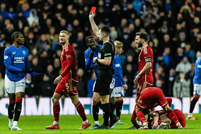 Referee Don Robertson shows Rangers' Dujon Sterling a red card for a tackle on Aberdeen's Jack MacKenzie.