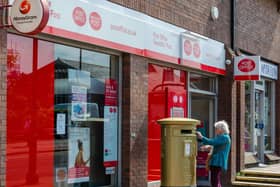 An elderly woman posts some letters in a post box. Picture: Getty Images