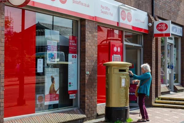 An elderly woman posts some letters in a post box. Picture: Getty Images