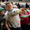 Saracens' Owen Farrell takes a selfie with fans after the match against Leicester.
