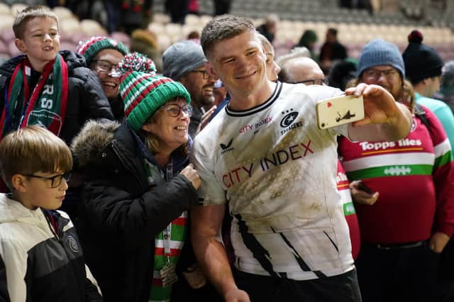 Saracens' Owen Farrell takes a selfie with fans after the match against Leicester.