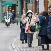 A woman in a face mask walks along Trinity Street in Cambridge, as the city feels the effects of the Coronavirus outbreak.