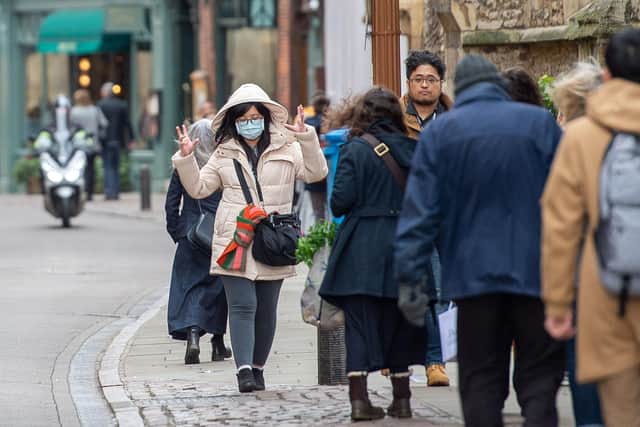 A woman in a face mask walks along Trinity Street in Cambridge, as the city feels the effects of the Coronavirus outbreak.