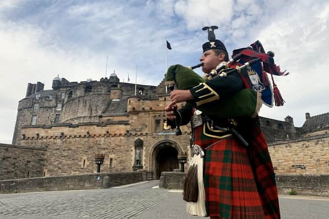 Pipe Major Stuart Gillies of 2 Scots plays the The Heroes of St Valery in front of Edinburgh Castle. The castle is among top  places British tourists plan to visit this year