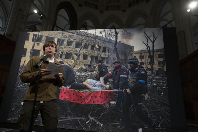 World Press Photo of the Year award winner, Associated Press photographer Evgeniy Maloletka, gives a speech in front of his winning image of a pregnant woman being carried through the wreckage of a maternity hospital after a Russian military strike in Mariupol, Ukraine, during a press conference announcing the winners in Amsterdam, Netherlands, Thursday, April 20, 2023. (AP Photo/Peter Dejong)