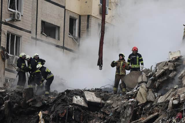 Emergency workers search the remains of a residential building that was struck by a Russian missile