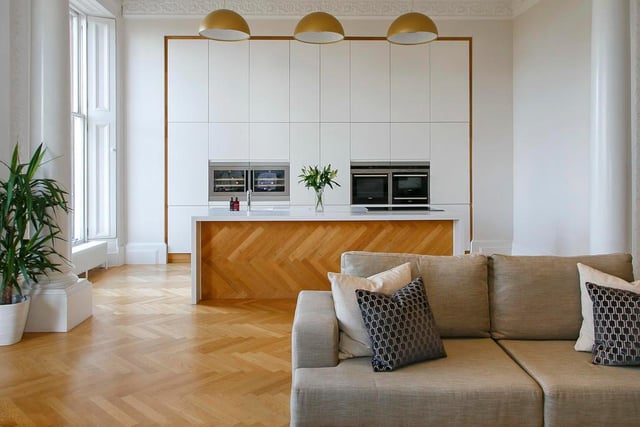 The open-plan kitchen's herringbone pattern seamlessly blends with the rest of the main living space