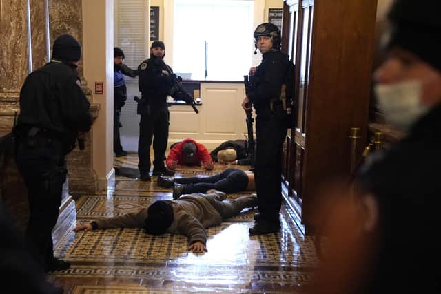 WASHINGTON, DC - JANUARY 06: U.S. Capitol Police stand detain protesters outside of the House Chamber during a joint session of Congress on January 06, 2021 in Washington, DC. Congress held a joint session today to ratify President-elect Joe Biden's 306-232 Electoral College win over President Donald Trump. A group of Republican senators said they would reject the Electoral College votes of several states unless Congress appointed a commission to audit the election results. (Photo by Drew Angerer/Getty Images)