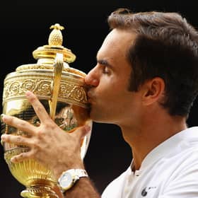 Roger Federer kisses the trophy as he celebrates victory after the men's singles final at Wimbledon in 2017 (Picture: Clive Brunskill/Getty Images)