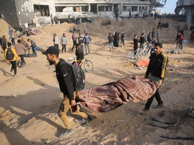 Palestinians carry away a covered body as people gather to inspect the damage at Gaza's Al-Shifa hospital after the Israeli military withdrew from the complex housing the hospital after a two week siege.