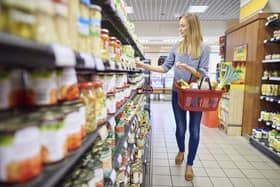 A woman buys products in a supermarket food aisle