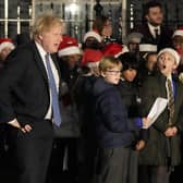 Britain's Prime Minister Boris Johnson listens to a children's choir sing during the ceremony to switch on the Downing Street Christmas tree lights in London. Picture: AP Photo/Frank Augstein