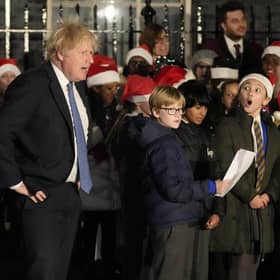 Britain's Prime Minister Boris Johnson listens to a children's choir sing during the ceremony to switch on the Downing Street Christmas tree lights in London. Picture: AP Photo/Frank Augstein