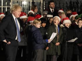 Britain's Prime Minister Boris Johnson listens to a children's choir sing during the ceremony to switch on the Downing Street Christmas tree lights in London. Picture: AP Photo/Frank Augstein