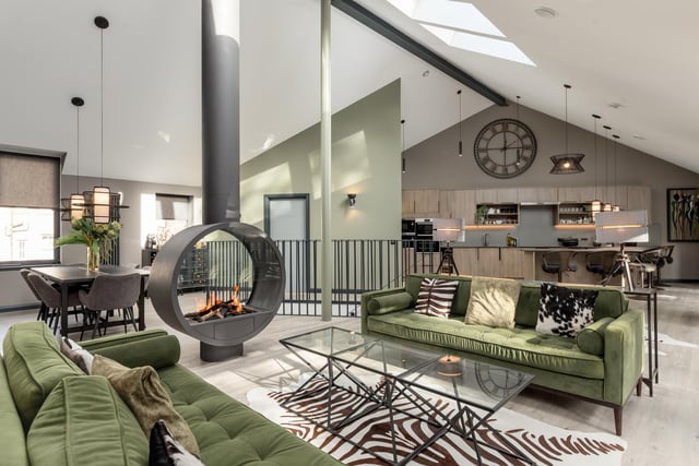 Internally, the property has been designed to ensure each space seamlessly flows through its 3,000sq ft of floorspace.
A sleek open-plan kitchen and living room can be found on the first floor and exude modern living. Thanks to south-facing floor-to-ceiling windows along one side, as well as Velux windows above, this area is filled with light throughout the day.
At one end of the space is the contemporary kitchen, with a large breakfast bar, and on the other is a dedicated sitting area, which benefits from a custom-made open gas fire.