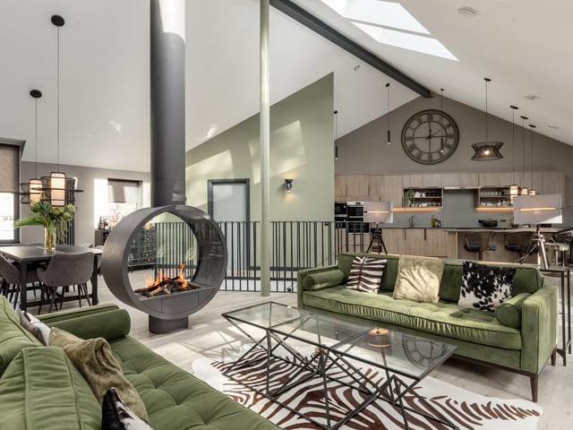 Internally, the property has been designed to ensure each space seamlessly flows through its 3,000sq ft of floorspace.
A sleek open-plan kitchen and living room can be found on the first floor and exude modern living. Thanks to south-facing floor-to-ceiling windows along one side, as well as Velux windows above, this area is filled with light throughout the day.
At one end of the space is the contemporary kitchen, with a large breakfast bar, and on the other is a dedicated sitting area, which benefits from a custom-made open gas fire.