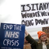 A demonstrator holds up a placard during a protest by junior doctors. (Photo by DANIEL LEAL/AFP via Getty Images)