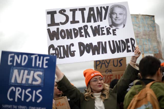 A demonstrator holds up a placard during a protest by junior doctors. (Photo by DANIEL LEAL/AFP via Getty Images)