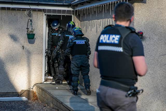 Police at one of the raided properties. Picture: Steven Brown/Police Scotland