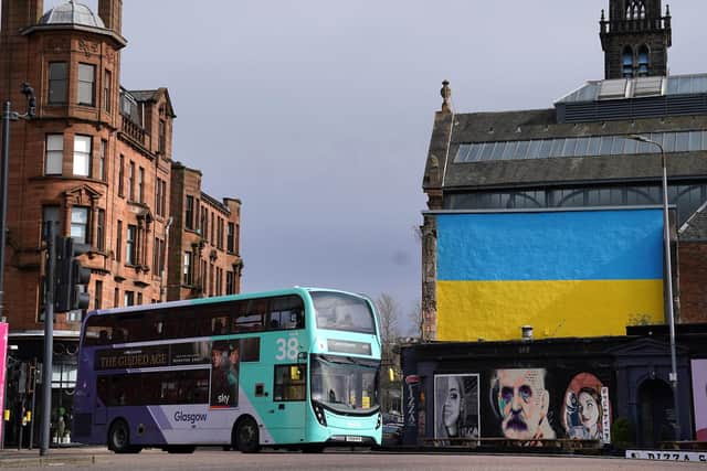 A bus passes The Clutha Bar in Glasgow which has the flag of Ukraine painted onto a wall above the bar. Picture date: Tuesday March 15, 2022.
