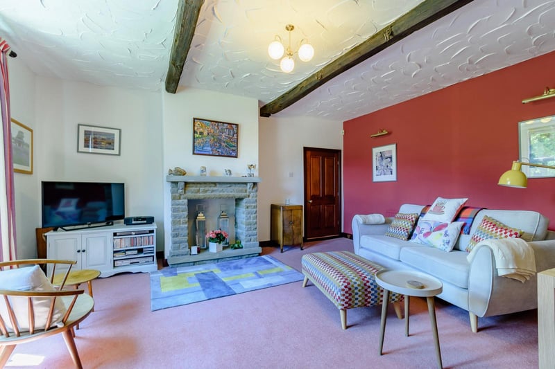 Original features in the sitting room include exposed beams and a high ceiling height.