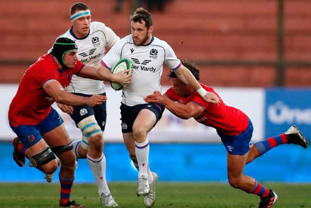 Scotland's replacement centre Mark Bennett tries to escape the clutches of Chile's Tomas Orchard. (Photo by JAVIER TORRES/AFP via Getty Images)