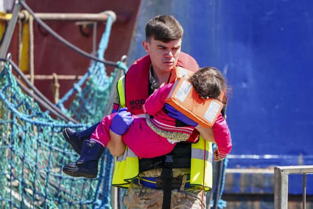 A soldier from the Royal Artillery Regiment carries a young child ashore from Border Force boat Valiant at Dover (Picture: Chris Eades/Getty Images)