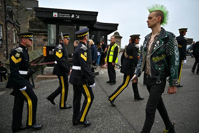 A punk passes soldiers from The Royal Scots Dragoon Guards prior a march down Edinburgh's Royal Mile last year (Picture: Jeff J Mitchell/Getty Images)