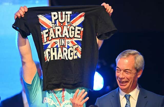 Reform UK leader Nigel Farage was joined on stage by a supporter at a Reform UK Scotland press conference in Bishopton, Glasgow, in March (Picture: Andy Buchanan/AFP via Getty Images)