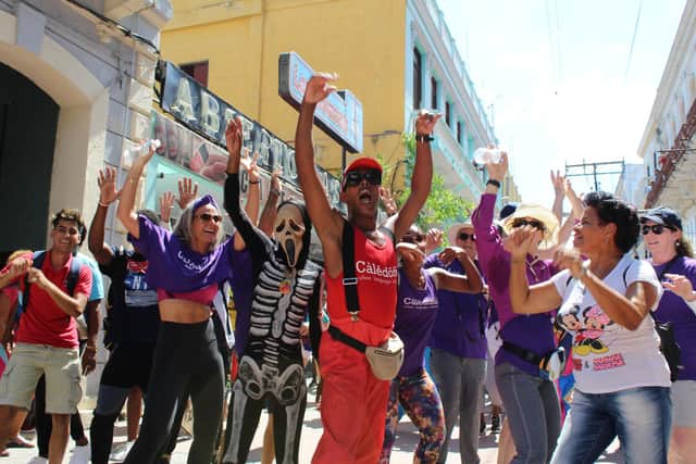 Caledonia clients dancing on the street in the FIDANZ parade with one of the Cutumba dancers leading the way on Calle Enramadas, Santiago de Cuba. Pic: Caledonia Worldwide