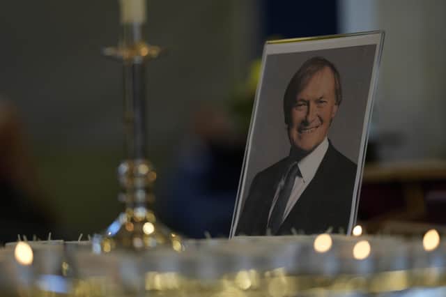 Candles are lit next to a portrait of British Lawmaker David Amess during a vigil for him at St Michaels Church, in Leigh-on-Sea, England Sunday, Oct. 17, 2021. Amess was killed on Friday during a meeting with constituents at Belfairs Methodist church, in Leigh-on-Sea, Essex, England. (AP Photo/Alastair Grant)