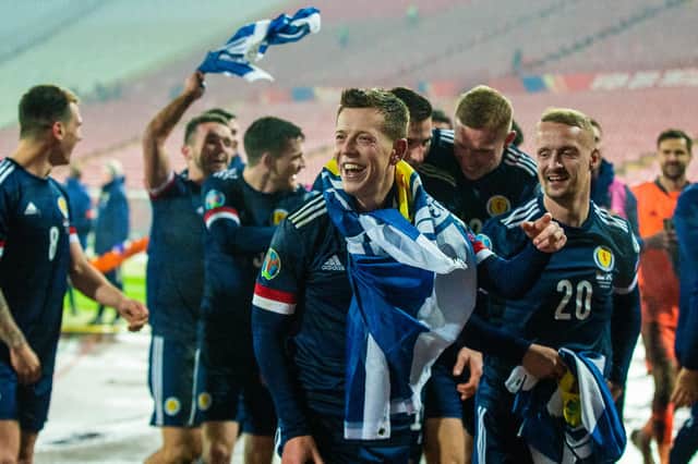 Leigh Griffiths (right) celebrates with his teammates after qualifying for Euro 2020 against Serbia - will the striker play for Scotland again?  (Photo by Nikola Krstic / SNS Group)