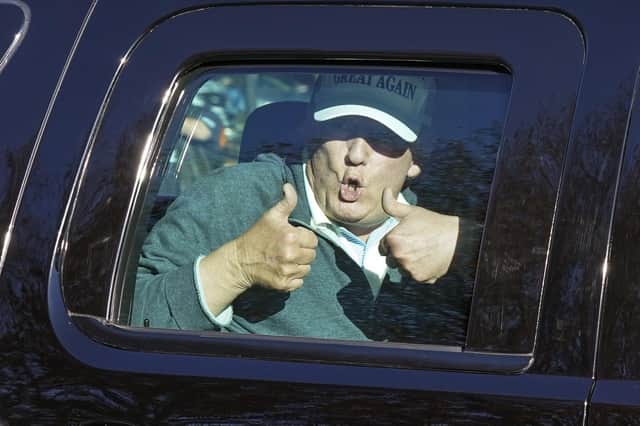 Donald Trump gives two thumbs up to supporters after playing golf at the Trump National Golf Club in Sterling, Virginia on Sunday (Picture: Steve Helber/AP)