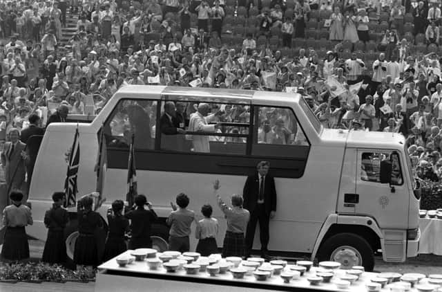 Pope John Paul II waves from the Popemobile as he makes his way through a welcoming crowd at Bellahouston Park.