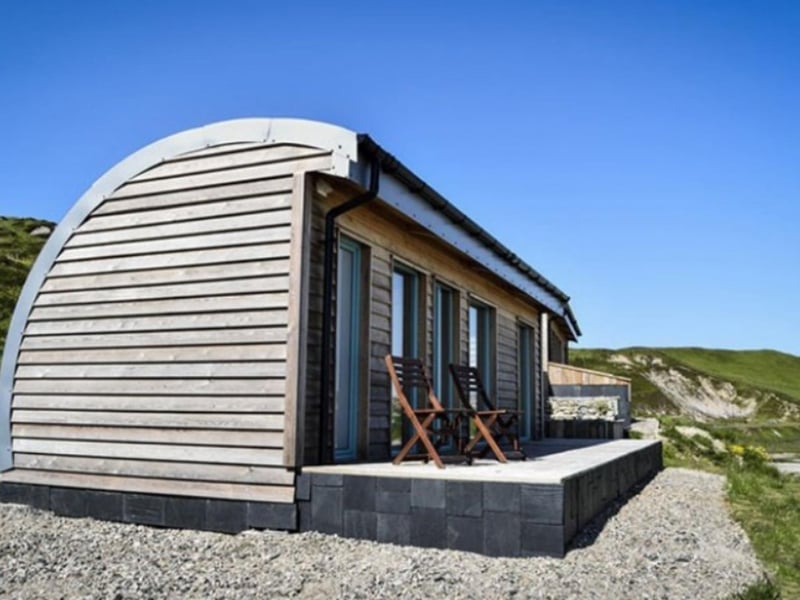 Rolling green hills provide a stunning backdrop to the cabin.