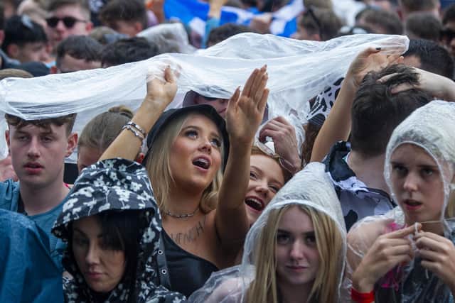 Patrons try to shield from the rain at TRNSMT at Glasgow Green over the weekend. More rain is forecast, with a yellow weather warning issued that covers Glasgow. Picture: Lisa Ferguson