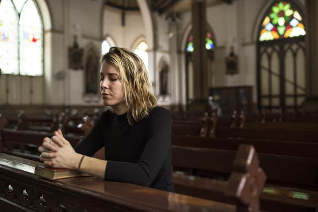 A woman praying in a church. Picture: Getty Images