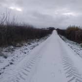 A light fall of snow on a road stretching into the distance is enough to get anyone off the couch
