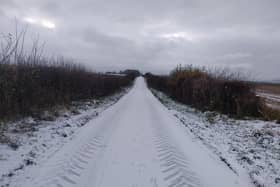 A light fall of snow on a road stretching into the distance is enough to get anyone off the couch
